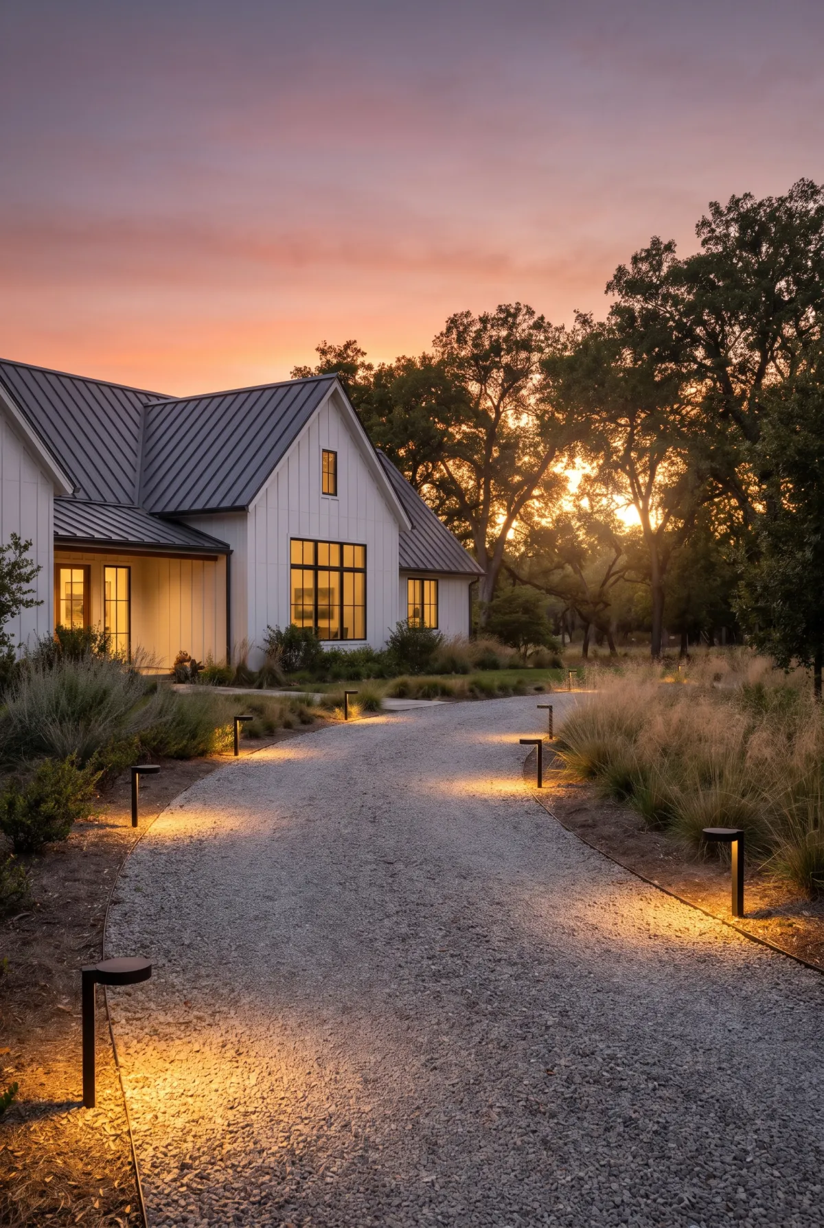 Gravel driveway lined with glowing low-voltage path lights at dusk